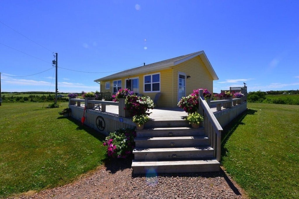 Small yellow cottage with lovely wrap around deck and outdoor hot tub