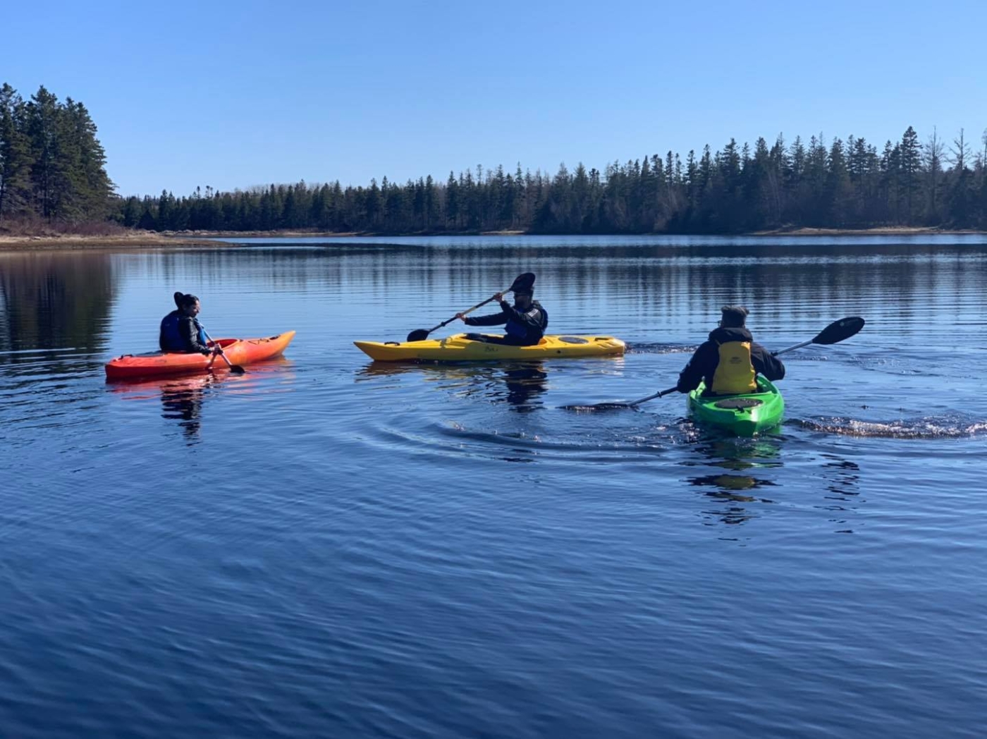 Three kayakers paddling in the water