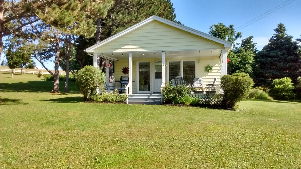 Blue Heron Chalet outside view of a yellow cottage with nice front porch