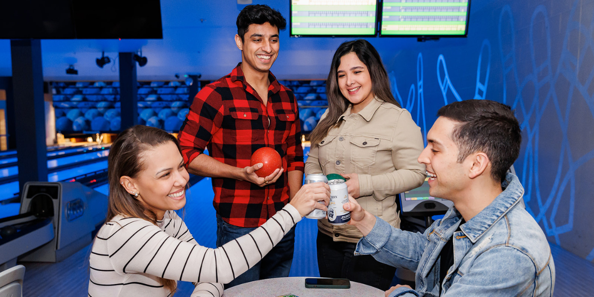 Four people at bowling lanes, Credit Union Place