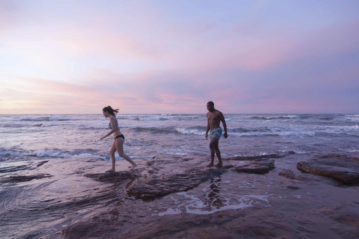 Cavendish Beach, PEI Couple walk on rocks at Cavendish Beach at sunset