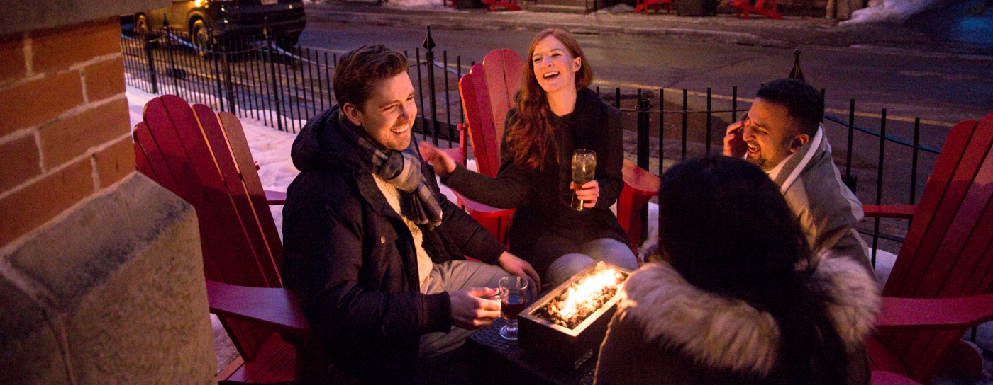 Group of four enjoy drinks outside on Sydney Street in winter