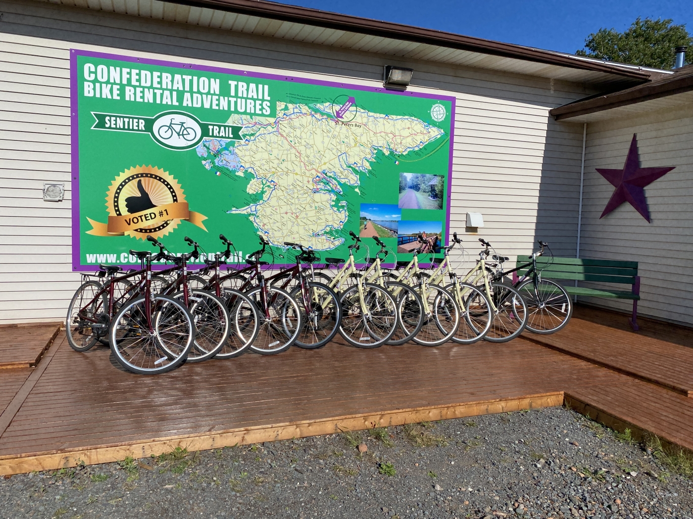 Image of many bikes lined up outdoors under sign of Confederation Trail Bike Rental Adventures