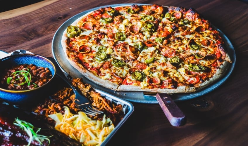 Sampling of menu items including pizza, baked beans and pulled pork from Crafters and Famous Peppers Pizza