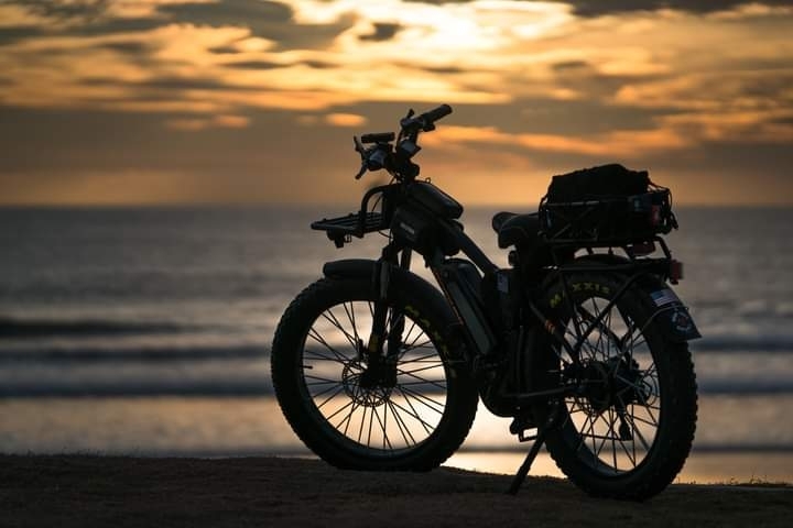 Nellie's Landing E-BIkes E-bike alone on a beach at sunset