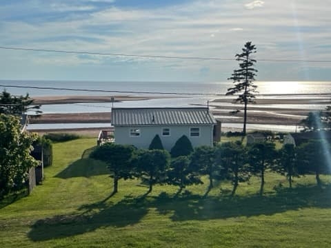 Hayes Haven airele view of a grey cottage overlooking sandbars and sea