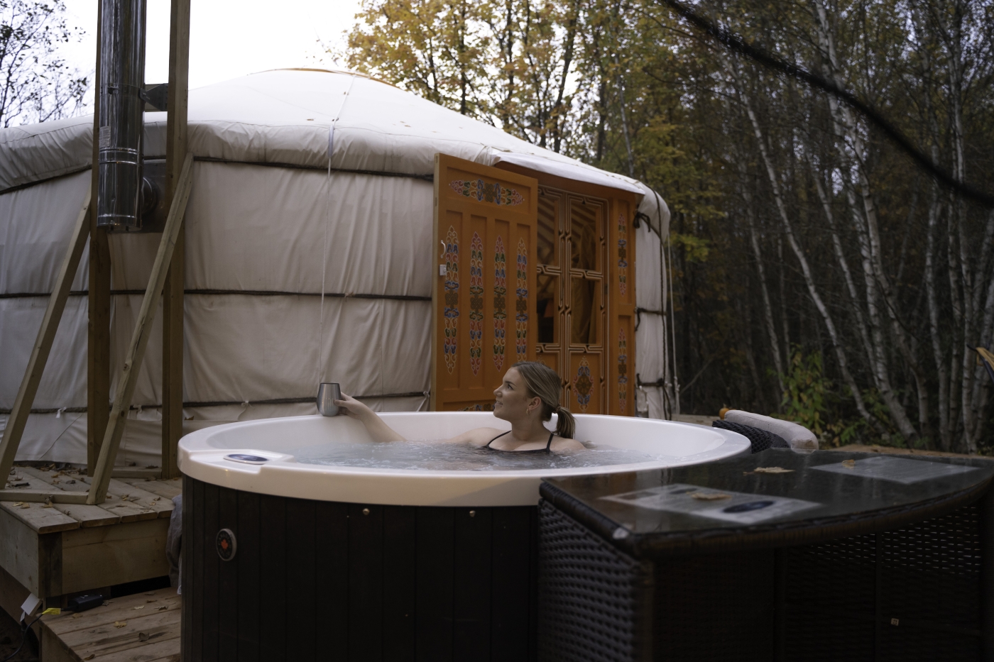 Female sitting in a hot tub outside of a Mongolian Yurt