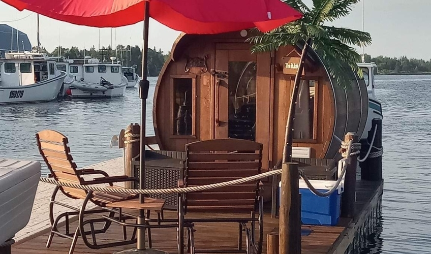 Wine barrel accommodations on a floating dock with deck and outdoor lawn chairs and umbrella