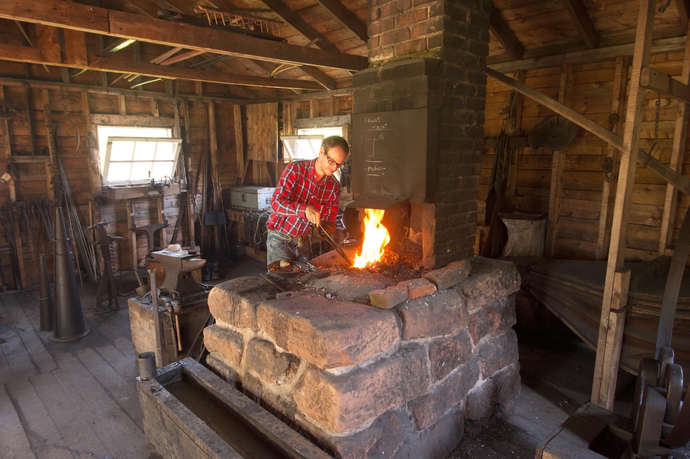 Blacksmith in forge at Orwell Corner Historic Museum