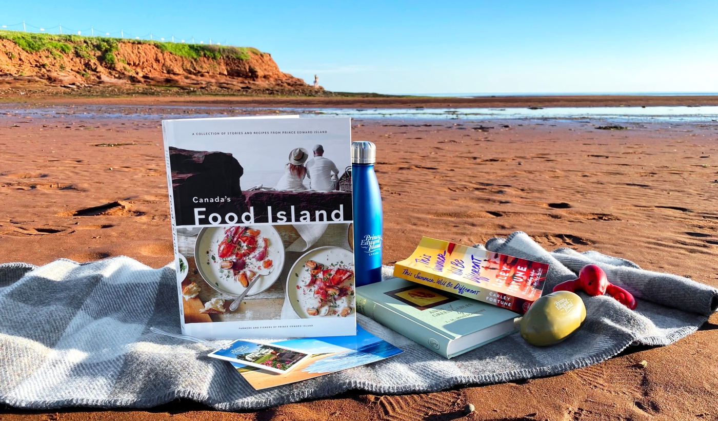 PEI Summer Beach Reads Three books sit on MacAusland woolen throw on Canoe Cove Beach, PEI