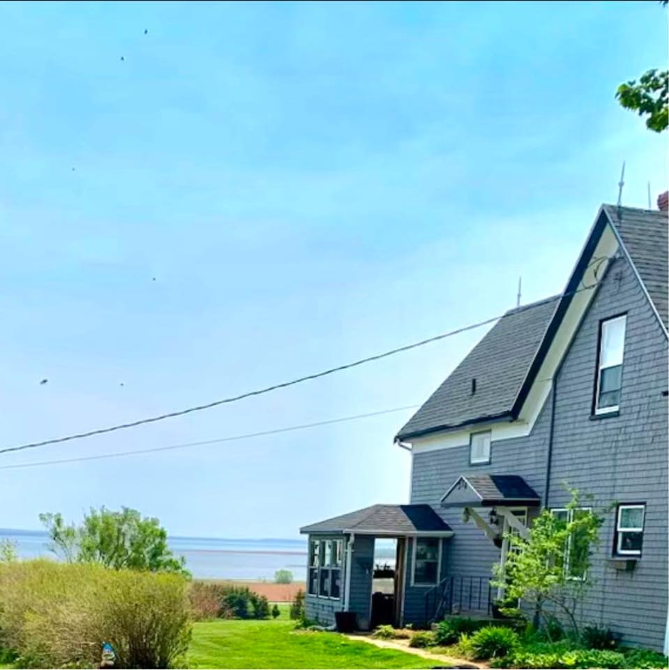 Pownal Bay Greenwood Vacation Home outside photo looking at a large grey home beside water