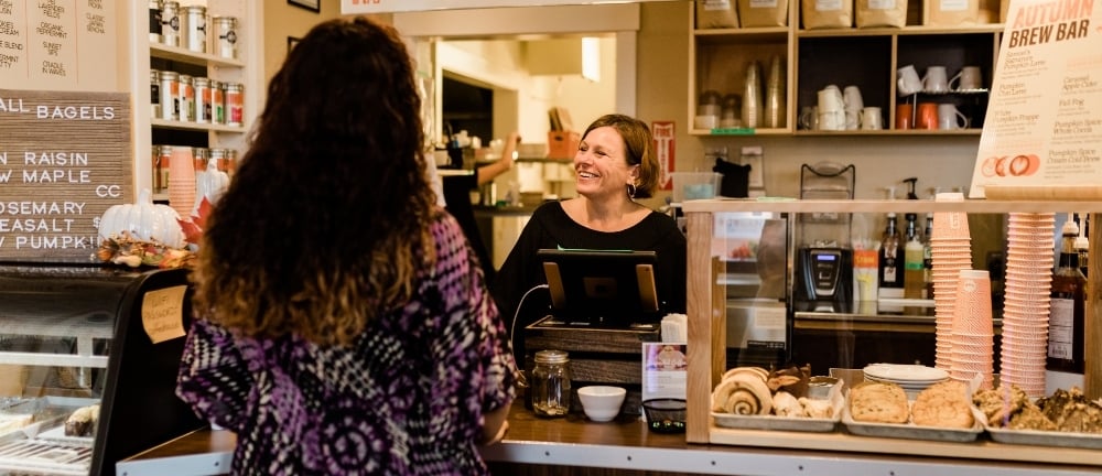 Moyna Matheson serves visitor at front counter of Samuels Coffee House