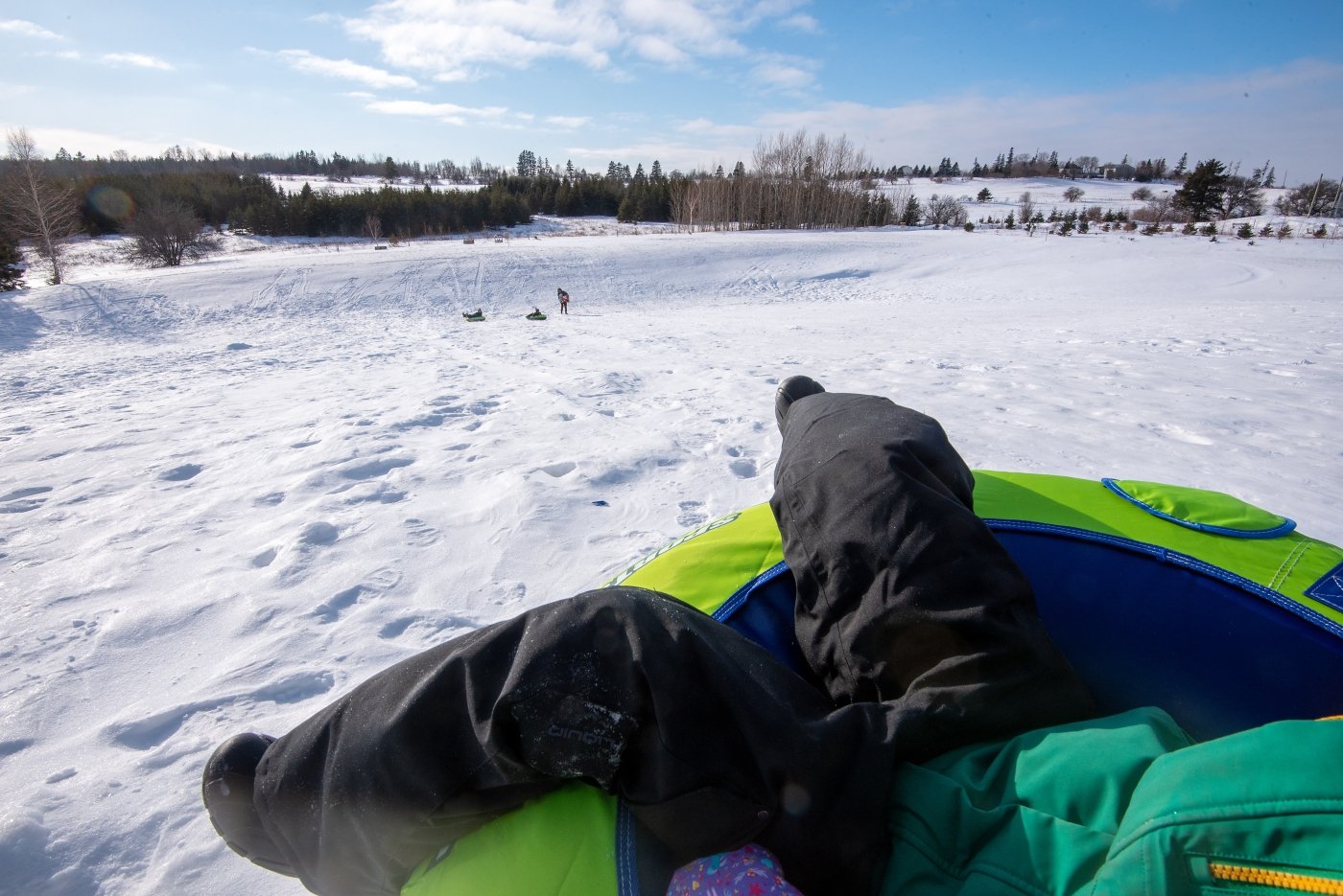 Child's legs on tube on sledding hill