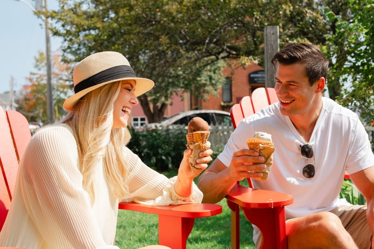 Couple sitting in outdoor garden at Holman's Ice Cream Parlour enjoying a cone