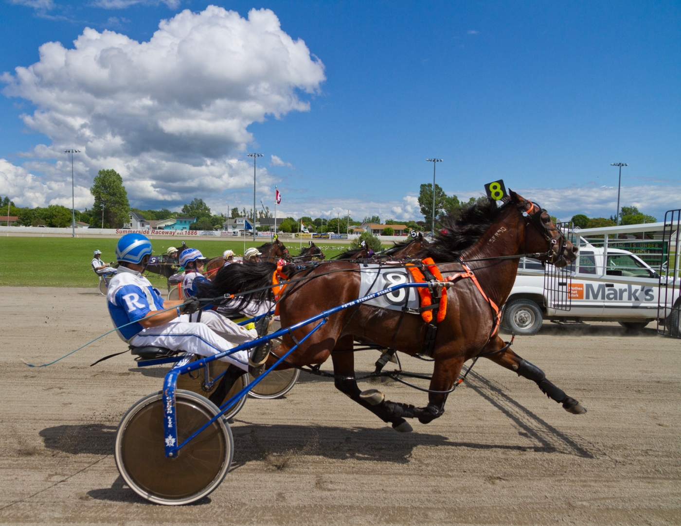 Summerside Raceway, PEI Harness race with jockies, horses and starter car in background