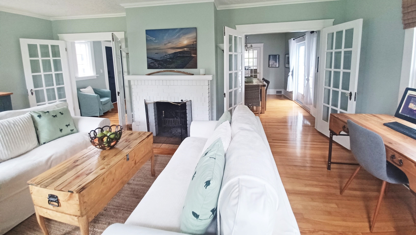 Beautiful living room with white sofa, blue walls and natural wood floors and accents