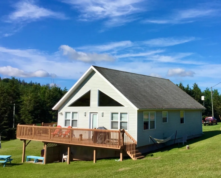 Varasa Cottage Outside view of beige cottage with large front deck