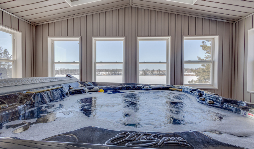 Large enclosed hot tub surrounded by windows for an outdoor view