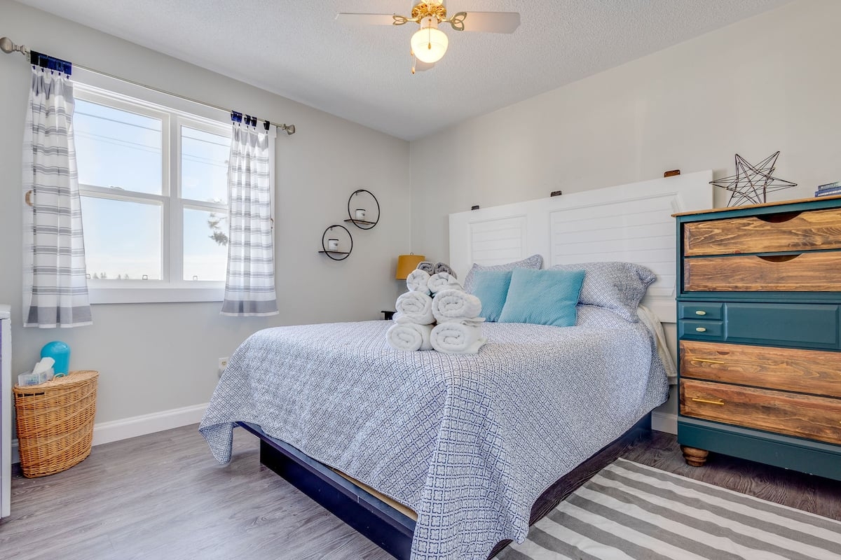 Nautical themed bedroom with white walls and nice big bed