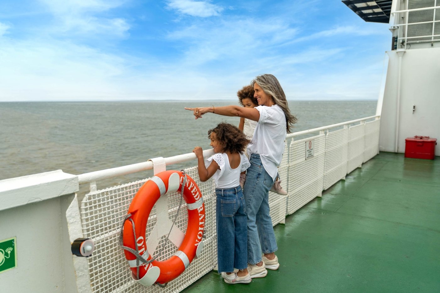 Female and two children observe from the viewing deck of ferry