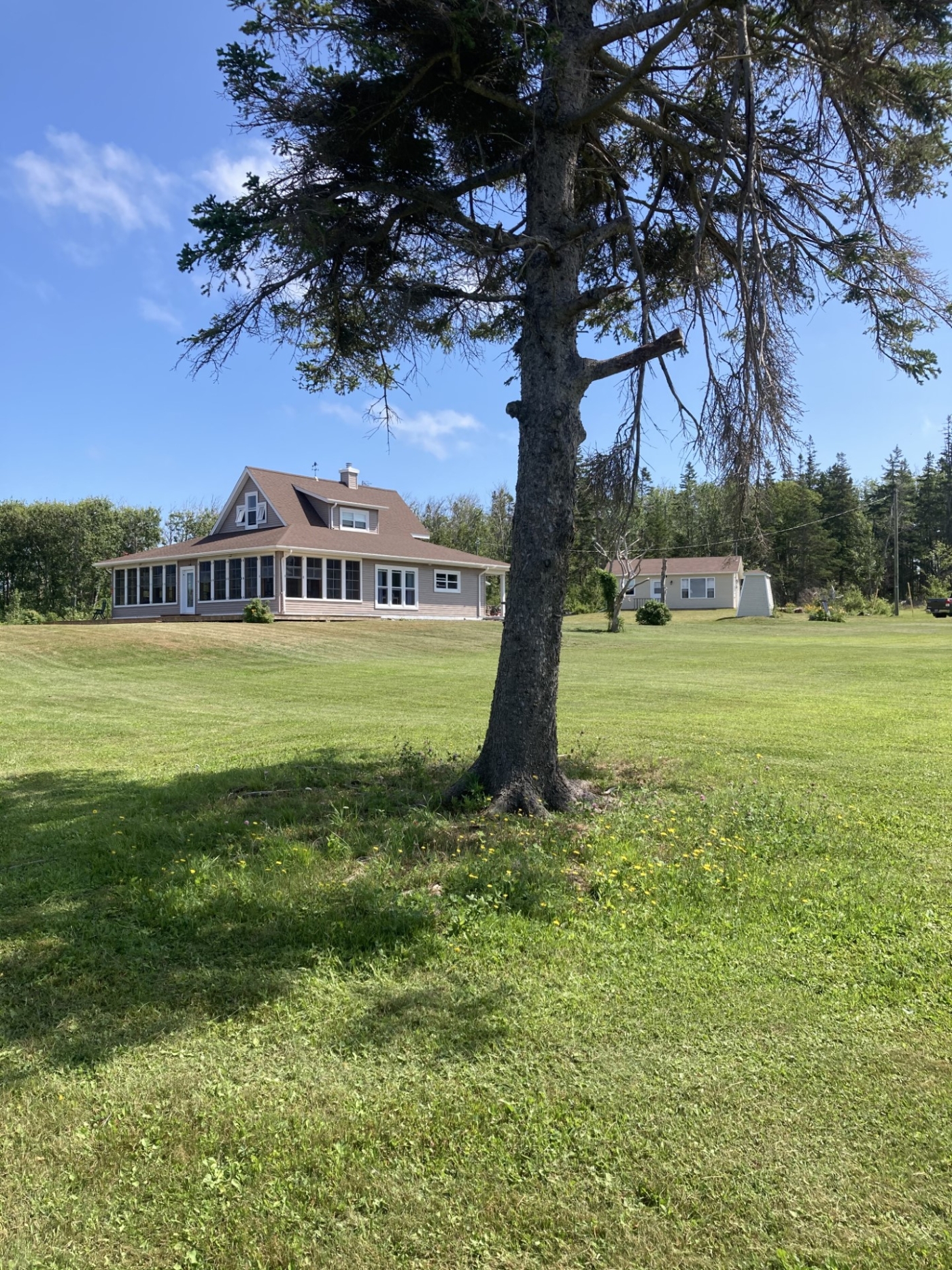 Beach point Retreat outside view overlooking the lawn and house at Beach Point Retreat. large house with wrap around porchh