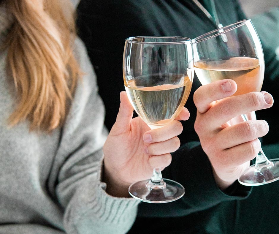 Dinner on Us photo of two peoples hands holding wine