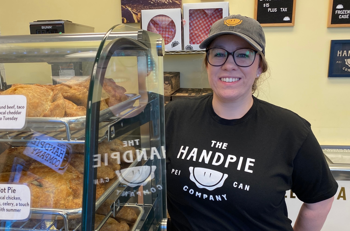Staff member at front counter of the Handpie Company with pies in display case