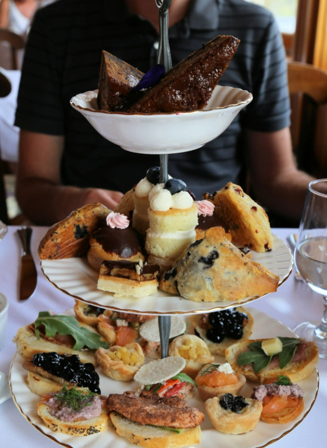 A guest sitting at a table set for high tea at Dalvay by the Sea