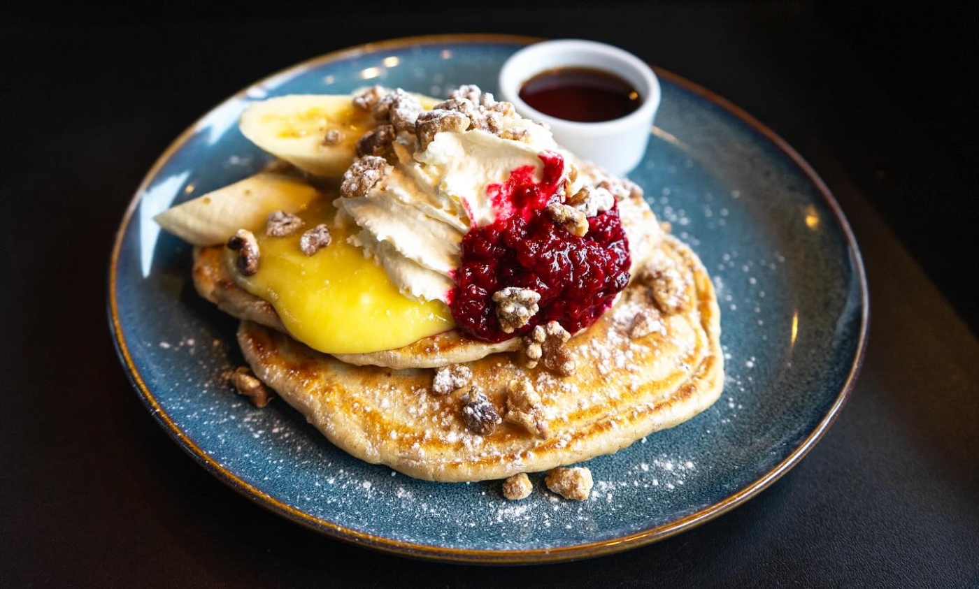 Plated hot cakes with fruit and maple syrup from Receiver Coffee