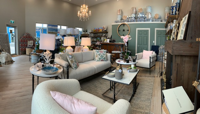 Indriya inside photo of a living room set up with accent tables and green couches
