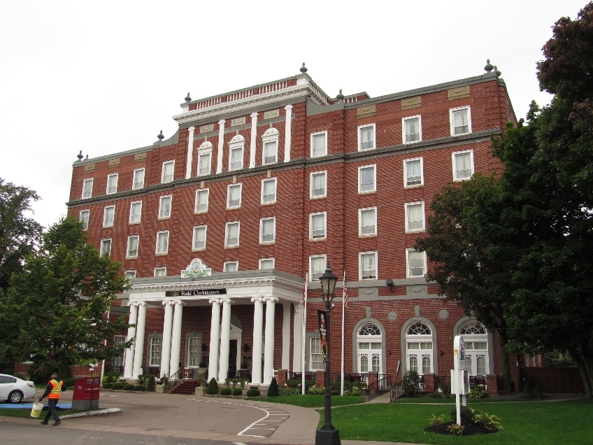 outside photo of the Rodd Charlottetown Hotel. 5 story brick building with white columned front veranda