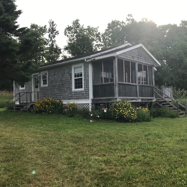 Rosepath Cottage photo looking at front of Rosepath cottage. grey cottage with screened porch