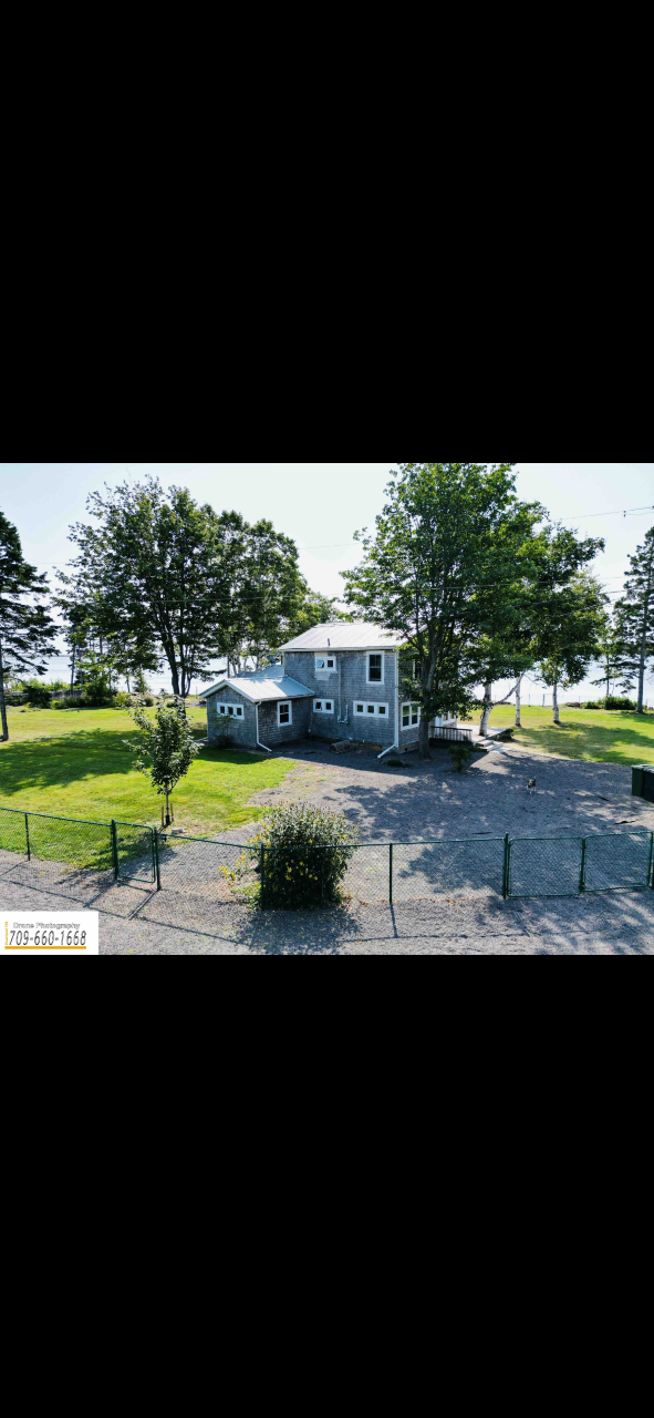 Sky Shore Retreat outside view of a large grey cottage overlooking the water