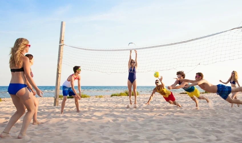 people playing volleyball on the beach