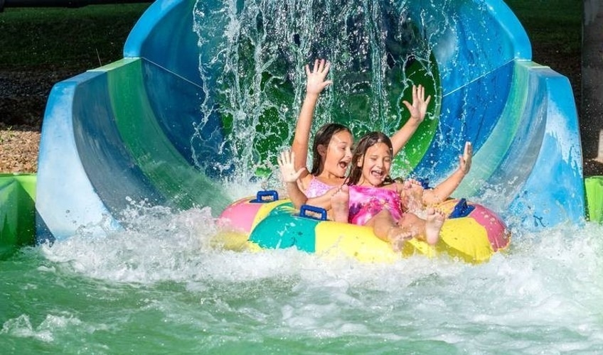 Two girls at end of waterslide at Shining Waters Family Fun Park