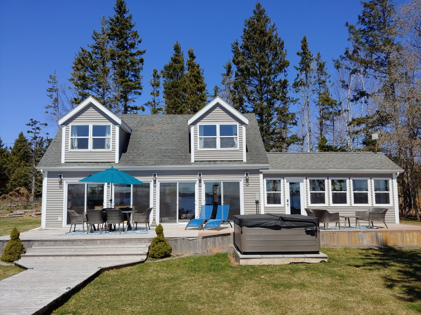 Yellow tent large grey cottage with many windows and large deck